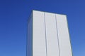 Tall white industrial building against blue sky