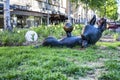 UMEA, SWEDEN - JUNE 10, 2020: Bronze sculpture of cat laying on back and playing with ball, closeup photo of brown kitten on green