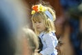 Beautiful swedish sweet happy kid is enjoying traditional decoration of mid summer day wearing colourful crown in sunny day