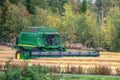 UMEA,SWEDEN - SEPTEMBER 12, 2020: Combine harvester, harvesting at small wheat field, on countryside, Sweden. Wheat field is