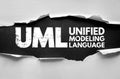 UML Unified Modeling Language text displayed on torn paper background, representing software engineering, system design, Royalty Free Stock Photo