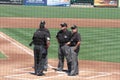 Umpires Meeting on the Other Side of the Backstop Royalty Free Stock Photo
