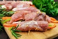 Un-cooked, pork meat rolls stuffed with vegetables pepper, carrots in hot garlic sauce on a cutting board. Royalty Free Stock Photo