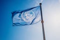 UN flag waved against the sun and blue sky