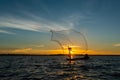 Un-identified silhouette fisher man on boat fishing by throwing Royalty Free Stock Photo