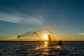 Un-identified silhouette fisher man on boat fishing by throwing Royalty Free Stock Photo