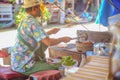 Unacquainted Thai Chef selling Grilled Pork neck on the Boat in Pattaya Floating Market.