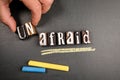 Unafraid and Afraid concept. Wooden alphabet letters and text on blackboard Royalty Free Stock Photo