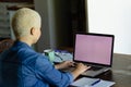 Unaltered biracial woman using laptop with copy space on screen, working at home