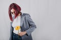 Unaltered candid portrait of young happy young woman with bright red hair with yellow flower Royalty Free Stock Photo