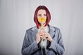 Unaltered candid portrait of young happy young woman with bright red hair with yellow flower Royalty Free Stock Photo