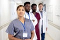 Unaltered portrait of asian female doctor and diverse male colleagues standing in hospital corridor Royalty Free Stock Photo