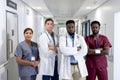 Unaltered portrait of diverse group of serious doctors with arms crossed in hospital corridor