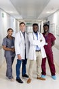 Unaltered portrait of diverse group of smiling doctors standing in hospital corridor, copy space Royalty Free Stock Photo