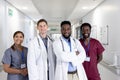 Unaltered portrait of diverse group of smiling doctors standing in hospital corridor Royalty Free Stock Photo