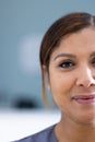 Unaltered portrait of half face of happy asian female doctor smiling in hospital, copy space