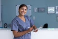 Unaltered portrait of happy asian female doctor writing on clipboard smiling in hospital corridor Royalty Free Stock Photo