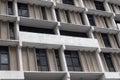 Unattractive concrete urban apartment building with dark recessed windows