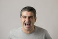 Unattractive 40s or 50s white funny man in sick and mad happy face expression screaming and shouting crazy isolated on grey Royalty Free Stock Photo