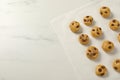 Unbaked chocolate chip cookies on white marble table, flat lay. Space for text Royalty Free Stock Photo