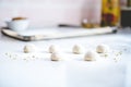 unbaked naan dough balls lined up on a floured surface