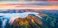 Unbelievable colors sunrise on Carpathian mountains. Fog spreads on the valley of Snidavka village, Ukraine Royalty Free Stock Photo