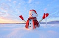 Unbelievable sunrise. Happy snowman in hat, scarf, red gloves with ice pikestaff is standing on the snow lawn. Mountains landscape