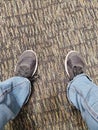 Unbranded black shoes and jeans on carpet