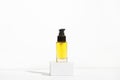 Unbranded bottle with dispenser on pedestal. Transparent glass container with hair oil. Repair, moisturizing for damaged