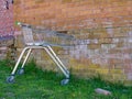 An unbranded, damaged supermarket shopping trolley discarded in an urban area.