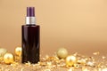 Unbranded dark brown spray bottle, gold Christmas balls and pieces of gold paper on golden background. Cosmetic packaging mockup Royalty Free Stock Photo