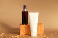 Unbranded dark brown spray bottle, white squeeze bottle cream tube, golden rectangular shape and pieces of gold paper on golden Royalty Free Stock Photo