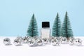 Unbranded Perfume bottle, silver christmas balls and fir trees on blue background. copy space