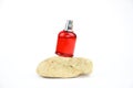 Unbranded perfume spray red bottle on stone isolated on white background. Mockup, template