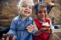 Unbreakable Bonds: Two Young Girls Embracing Friendship and Muffins in the Kitchen Royalty Free Stock Photo