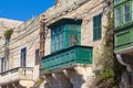 Uncared maltese house with green balcony