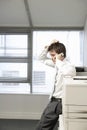 Uncertain Businessman By Photocopier Using Cellphone Royalty Free Stock Photo