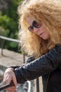 uncertain indecisive mature woman with sunglasses and red hair looks down doubtful hesitant on vacation in italy