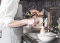 Woman washes dishes with wooden brush Royalty Free Stock Photo