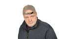 Uncertainty in the Working Class: Thoughtful Middle-Aged Man in Baseball Cap on White Background Royalty Free Stock Photo