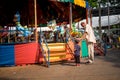 Uncle and grandchild stand in front of carousel