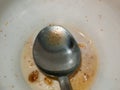 Unclean and used spoon up close in bowl