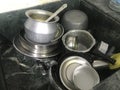 Uncleaned Aluminum and silverware kitchen utensils are kept inside the granite finishes Sink for cleaning by housewife and part of