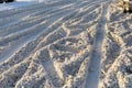 Uncleared road covered with dirty snow with traces of cars