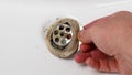 Unclogging a clogged bathroom sink. Steel dirty part in hand