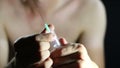 Unclothed junkie prepares a syringe for injection