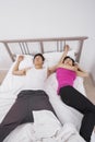 Uncomfortable woman sleeping by man in bed