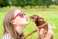 Unconditional love. Teenage girl kissing her brown toy-terrier d