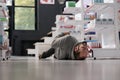 Unconscious person lying on pharmacy floor during epileptic attack Royalty Free Stock Photo