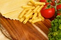 Uncooced lasagne pasta sheets on wooden table